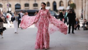 Inspiration shot: Street style star seen wearing a pink/rose maxidress with floral print, a matching cape and red huge diamond earrings, outside the Giambattista Valli Show during the Womenswear Spring/Summer 2024 as part of Paris Fashion Week on September 29, 2023 in Paris, France.
