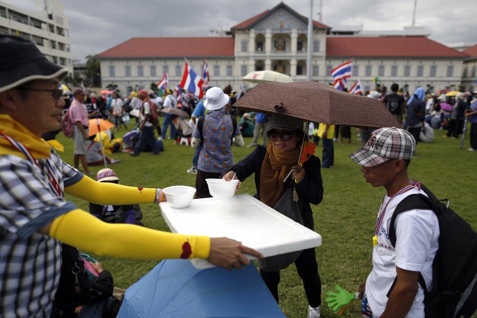 Free food is distributed to anti-government protesters after they broke into the compound of the Royal Thai Army headquarters in Bangkok