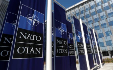 Banners displaying the NATO logo are placed at the entrance of new NATO headquarters during the move to the new building, in Brussels, Belgium April 19, 2018.  REUTERS/Yves Herman