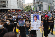 A marcher holds a sign reading "Carrie Lam condemned by history" as protestors march through the Mong Kok neighborhood during a demonstration in Hong Kong, Saturday, Aug. 3, 2019. Hong Kong protesters ignored police warnings and streamed past the designated end point for a rally Saturday in the latest of a series of demonstrations targeting the government of the semi-autonomous Chinese territory. (AP Photo/Vincent Thian)