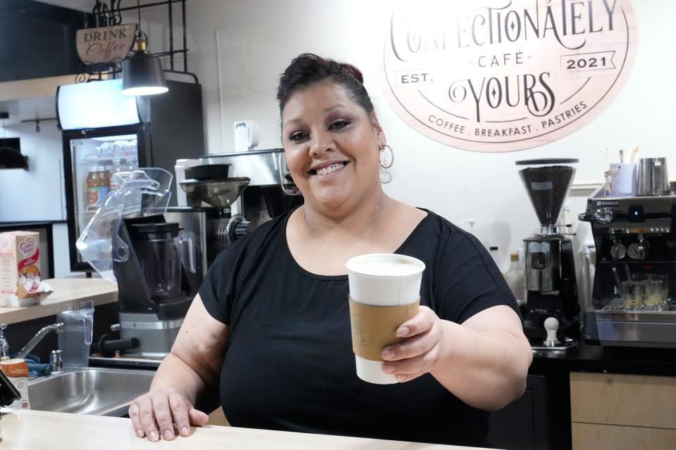 Confectionately Yours Cafe barista Maxine Balboa serves up an Adija Special latte, named after owner Adija Smith. It's flavored with white chocolate chestnut praline and topped with whipped cream and a dash of cinnamon.