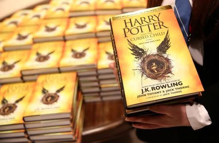 A store assistant holds copies of the book of the play of Harry Potter and the Cursed Child parts One and Two at a bookstore in London, Britain July 31, 2016. REUTERS/Neil Hall