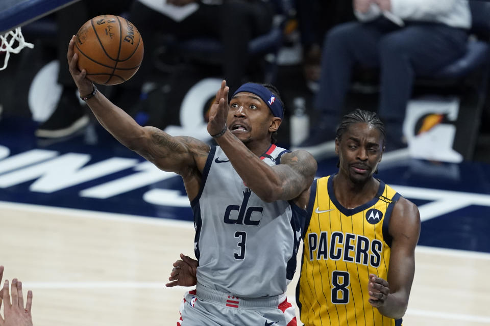 Washington Wizards' Bradley Beal (3) is fouled by Indiana Pacers' Justin Holiday (8) as he goes up for a shot during the first half of an NBA basketball game, Saturday, May 8, 2021, in Indianapolis. (AP Photo/Darron Cummings)