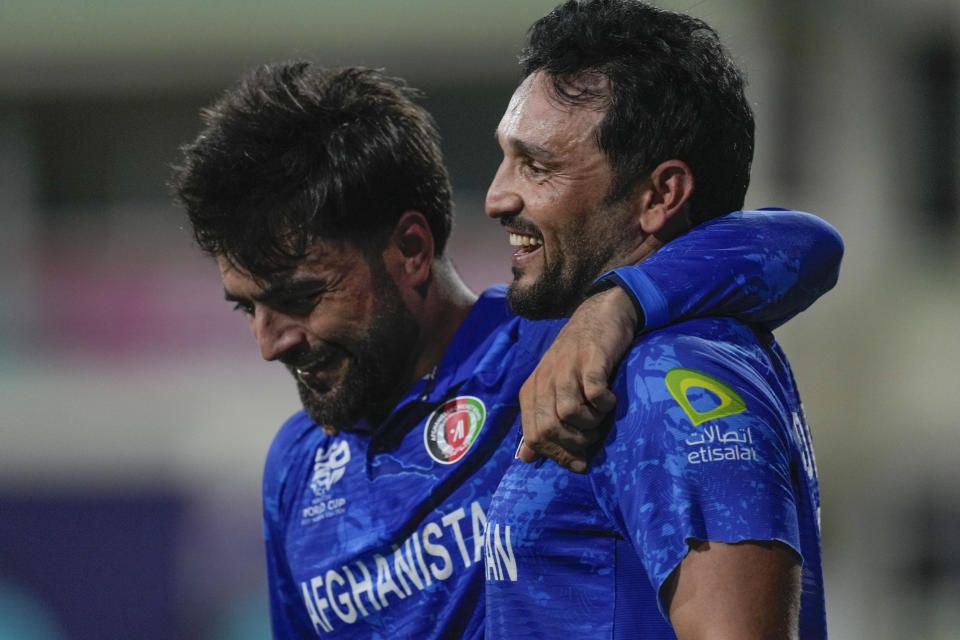 Afghanistan's captain Rashid Khan, left, embraces teammate Gulbadin Naib as they celebrate after defeating Bangladesh by eight runs in their men's T20 World Cup cricket match at Arnos Vale Ground, Kingstown, Saint Vincent and the Grenadines, Monday, June 24, 2024. (AP Photo/Ricardo Mazalan)