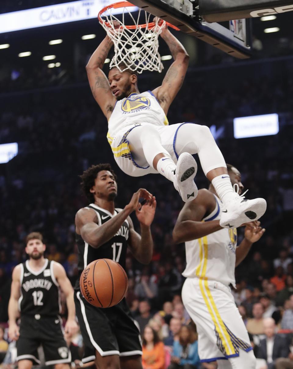 Golden State Warriors' Alfonzo McKinnie (28) dunks the ball in front of Brooklyn Nets' Ed Davis (17) during the first half of an NBA basketball game Sunday, Oct. 28, 2018, in New York. (AP Photo/Frank Franklin II)