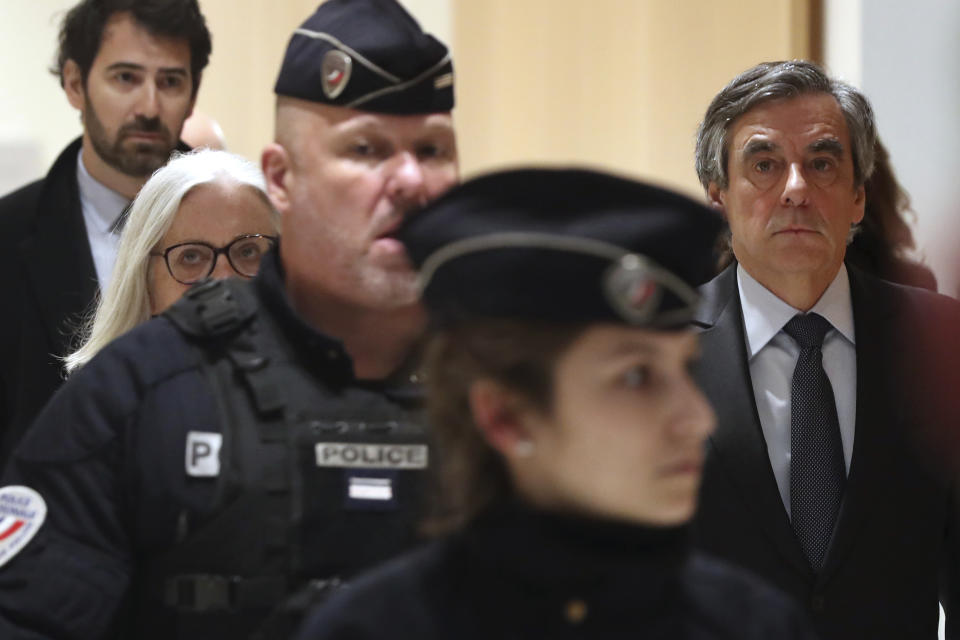 France's former Prime Minister Francois Fillon, right, and his wife Penelope, left, arrive at the Paris courthouse, in Paris, Monday, Feb. 24, 2020. He could have been president of France. Instead, former Prime Minister Francois Fillon is going on trial to face fraud charges after he used public funds to richly pay his wife and children for work they allegedly never performed. (AP Photo/Thibault Camus)