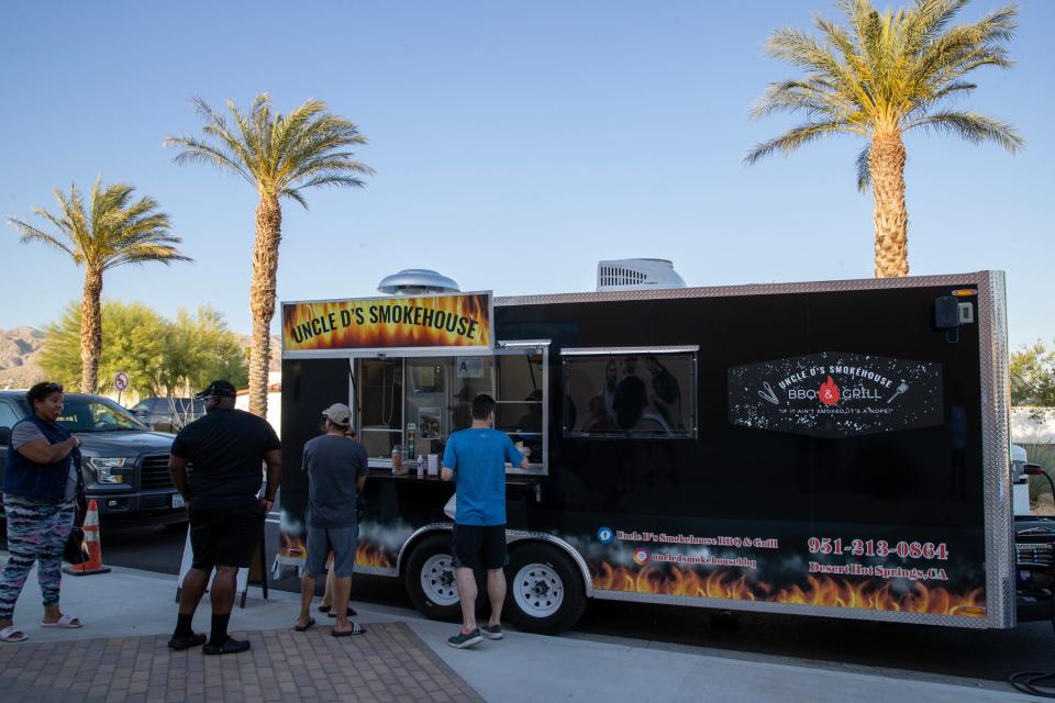 People order food from Uncle D's Smokehouse food truck on Palm Drive near Pierson Boulevard for Friday Nights on Pierson in downtown Desert Hot Springs, Calif., on Fri., May 12, 2023.