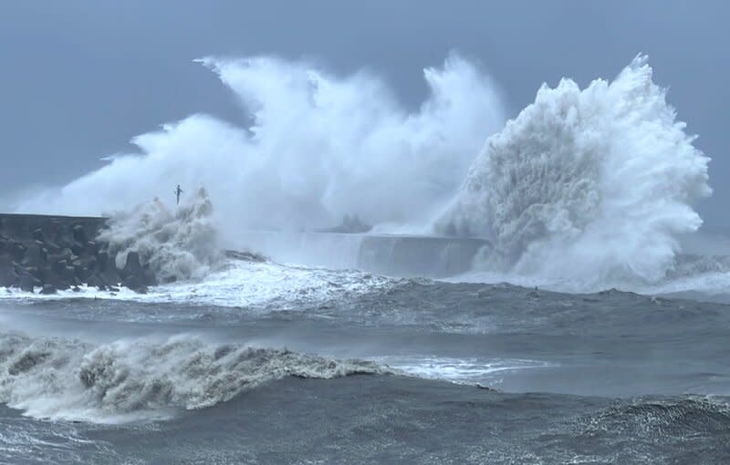 颱風小犬過境，5日長浪打在台東富岡港的堤防，激起約20米高浪花，左邊的燈柱被吞噬。（圖片來源／中央社記者盧太城台東攝2023年10月5日）