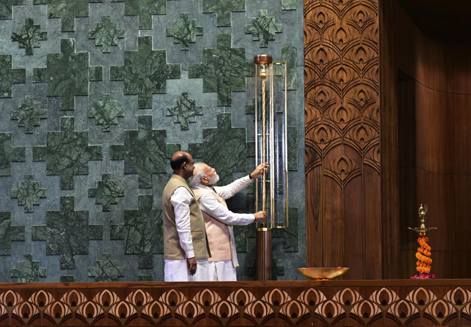 Indian prime minister Narendra Modi installs a royal golden sceptre near the chair of the speaker during the start of the inaugural ceremony of the new parliament building, in New Delhi, India, Sunday, May 28, 2023. The new triangular parliament building, built at an estimated cost of $120 million, is part of a $2.8 billion revamp of British-era offices and residences in central New Delhi called "Central Vista", even as India's major opposition parties boycotted the inauguration, in a rare show of unity against the Hindu nationalist ruling party that has completed nine years in power and is seeking a third term in crucial general elections next year. (AP Photo)