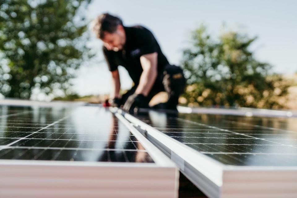 A man installs solar panels. 