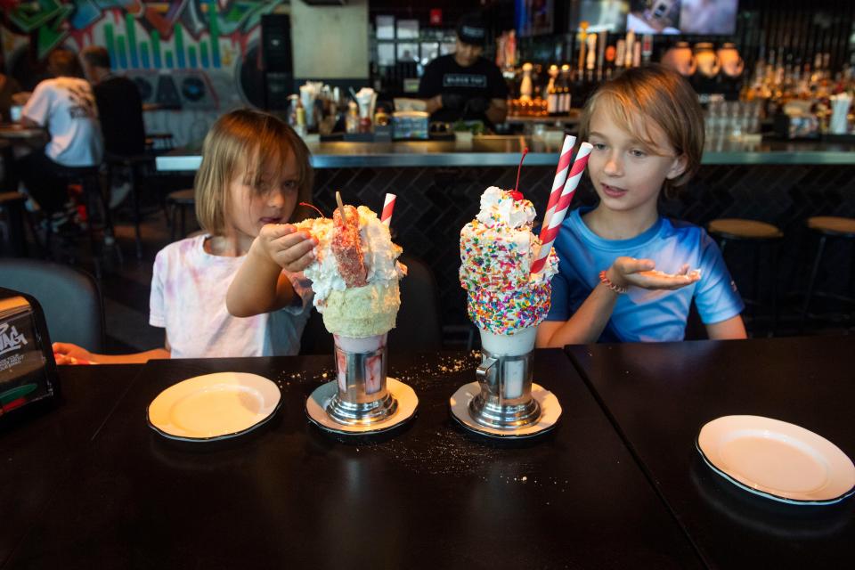 Lily Steineger and Benji Goad sample the shakes at Black Tap, which offers the Bam Bam shake and the birthday-themed Cakeshake.
