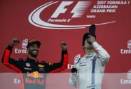 Formula One - F1 - Azerbaijan Grand Prix - Baku, Azerbaijan - June 25, 2017. Red Bull Racing Formula One driver Daniel Ricciardo of Australia and third placed Williams' Lance Stroll drinks champagne from boot as they celebrate. REUTERS/David Mdzinarishvili