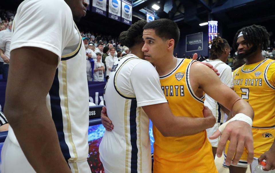 Kent State's Giovanni Santiago (11) hugs Akron's Greg Tribble (2) after the teams' game Friday in Akron.