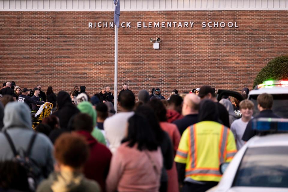 Students and police gather outside of Richneck Elementary School after a shooting, Friday, Jan. 6, 2023 in Newport News, Va. A shooting at a Virginia elementary school sent a teacher to the hospital and ended with “an individual” in custody Friday, police and school officials in the city of Newport News said. (Billy Schuerman/The Virginian-Pilot via AP) ORG XMIT: VANOV102