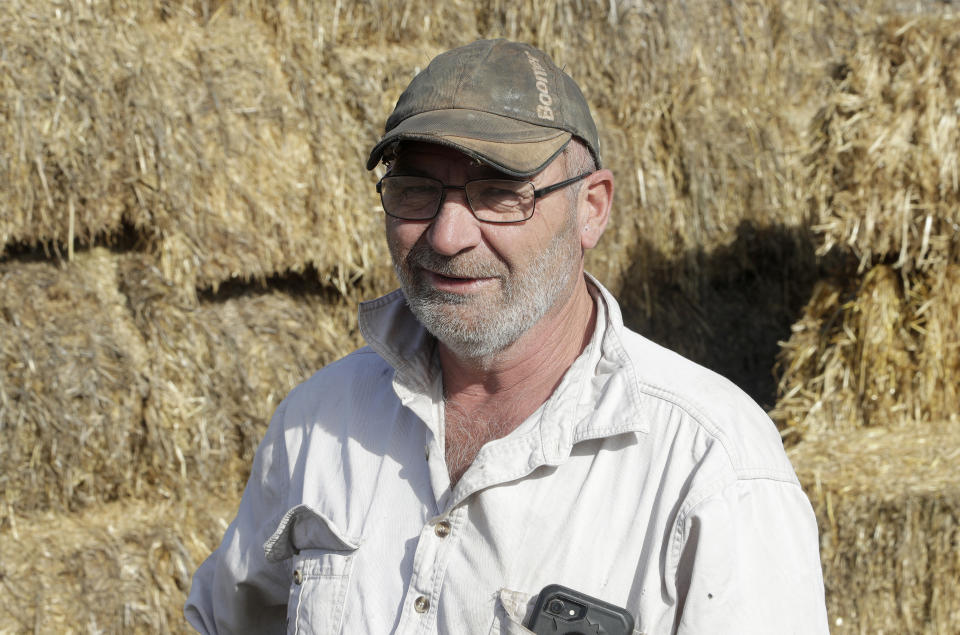 Bruce Barnes talks in front of stored hay infested with mice on his family's farm near Bogan Gate, Australia on May 20, 2021. Vast tracts of land in Australia's New South Wales state are being threatened by a mouse plague that the state government describes as "absolutely unprecedented." Just how many millions of rodents have infested the agricultural plains across the state is guesswork. (AP Photo/Rick Rycroft)