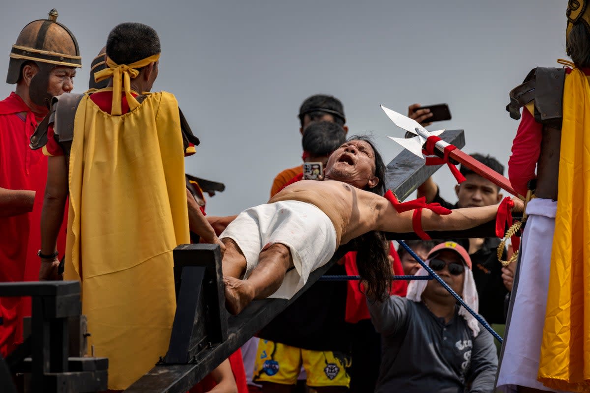 Penitent Ruben Enaje grimaces in pain as he is nailed to a cross during Good Friday crucifixions in San Fernando, Pampanga, Philippines (Getty Images)