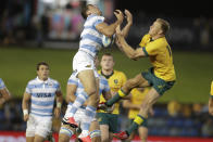 Argentina's Emiliano Boffelli, left, battles for the ball with Australia's Reece Hodge in the air during their Tri-Nations rugby union match in Newcastle, Australia, Saturday, Nov. 21, 2020. (AP Photo/Rick Rycroft)