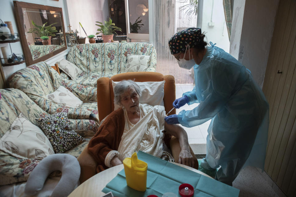 Nurse Pilar Rodríguez administers the COVID-19 vaccine to her patient Antonia Crespi Gomila, 93, at her home in the town of Sa Pobla on the Spanish Balearic Island of Mallorca, Spain, Friday, April 30, 2021. (AP Photo/Francisco Ubilla)