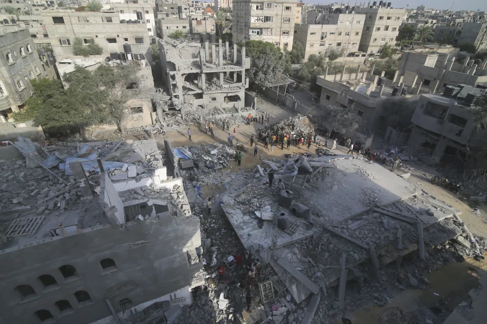 Palestinians look for survivors in the buildings destroyed in the Israeli bombardment of the Gaza Strip in Rafah on Sunday, Oct. 22, 2023. (AP Photo/Hatem Ali)