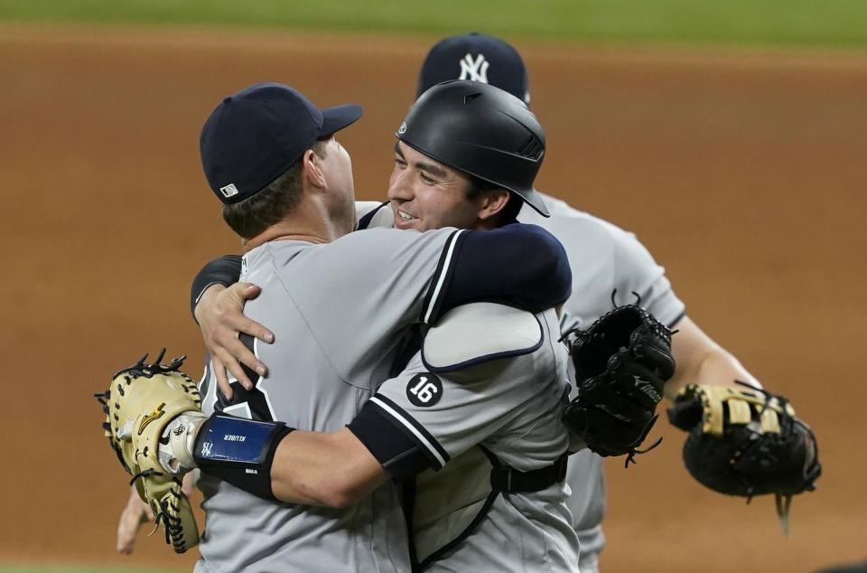 New York Yankees starting pitcher Corey Kluber, catcher Kyle Higashioka, right, and first baseman Luke Voit, rear, celebrate after Kluber threw a no-hitter against the Texas Rangers in a baseball game in Arlington, Texas, Wednesday, May 19, 2021. (AP Photo/Tony Gutierrez)