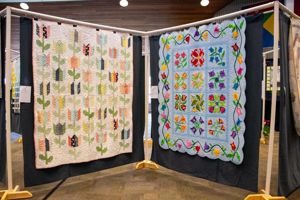 Two flower-themed quilts hanging side by side