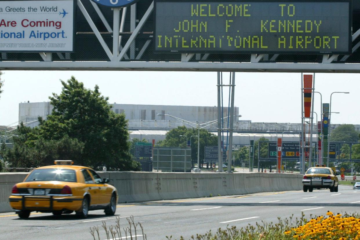 A taxi passes under the entrance to JFK Airport in the New York borough of Queens, Aug. 15, 2003. A cargo plane headed from New York's John F. Kennedy International Airport to Belgium had to return to JFK on Nov. 9, 2023, after a horse escaped its stall and got loose in the hold, according to air traffic control audio.