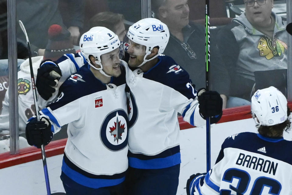 Winnipeg Jets right wing Saku Maenalanen (8) celebrates with center Dominic Toninato after Maenalanen scored a goal against the Chicago Blackhawks during the second period of an NHL hockey game, Sunday, Nov. 27, 2022, in Chicago. (AP Photo/Matt Marton)