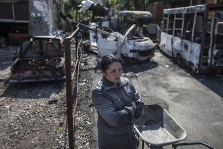 A woman stands in an area that was recently shelled in Donetsk, eastern Ukraine, September 16, 2014. REUTERS/Marko Djurica