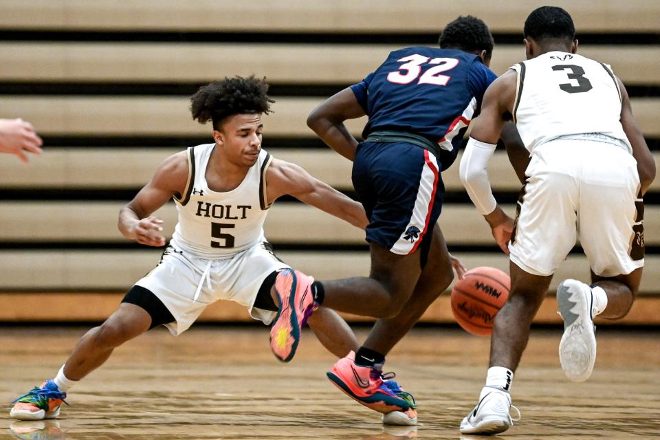 Holt's Kellen Reed, left, pressures East Lansing's Dorij'an Jackson during the second quarter on Tuesday, Jan. 11, 2022, at Holt High School.