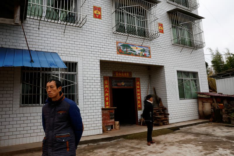 Liao stands in front of her home upon returning with her mother from a clinic, in Lezhi county