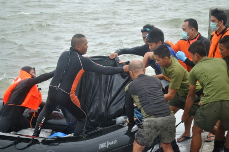 Rescuers unload a body bag as victims of the Philippines ferry disaster are retrieved and taken to the pier in Ormoc City, on July 3, 2015