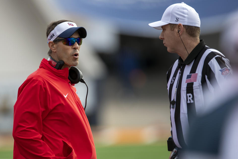 Liberty coach Jamey Chadwell, left, talks to referee Ron Hudson during the first half of an NCAA college football game against UTEP on Saturday, Nov. 25, 2023, in El Paso, Texas. Liberty became the first Division I team from Virginia to win 12 games in a season. (AP Photo/Andres Leighton)