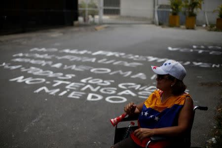 An opposition supporter wearing a Venezuelan flag sits on a wheelchair during a rally against National Constituent Assembly outside a school where a polling center will be established for a Constitutional Assembly election next Sunday, in Caracas, Venezuela, July 24, 2017. REUTERS/Andres Martinez Casares