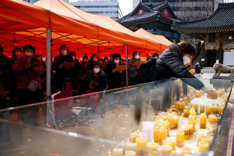 A mother lights a candle as she prays for children’s success in the college entrance examinations amid the coronavirus disease (COVID-19) pandemic, at a Buddhist temple in Seoul