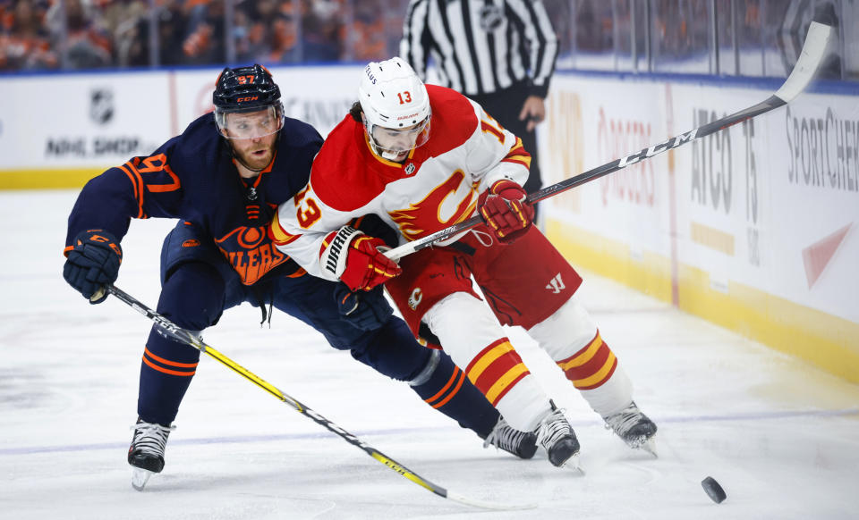Calgary Flames forward Johnny Gaudreau, right, is checked by Edmonton Oilers center Connor McDavid during the first period of Game 4 of an NHL hockey Stanley Cup playoffs second-round series Tuesday, May 24, 2022, in Edmonton, Alberta. (Jeff McIntosh/The Canadian Press via AP)