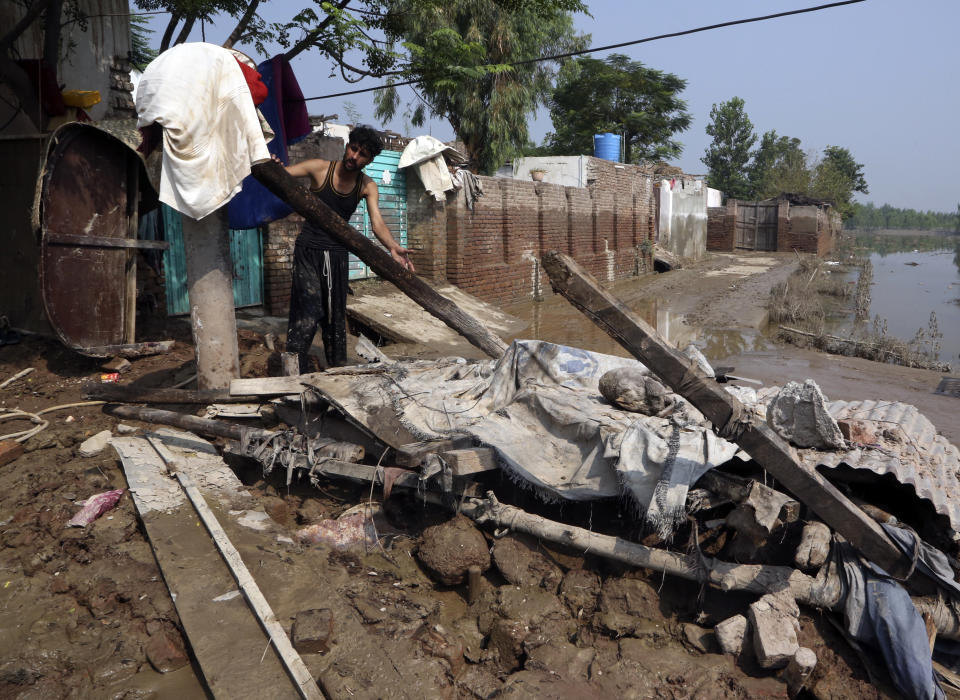 A man looks for salvageable belongings from his flood-hit home in Charsadda, Pakistan, Wednesday, Aug. 31, 2022. Officials in Pakistan raised concerns Wednesday over the spread of waterborne diseases among thousands of flood victims as flood waters from powerful monsoon rains began to recede in many parts of the country. (AP Photo/Mohammad Sajjad)