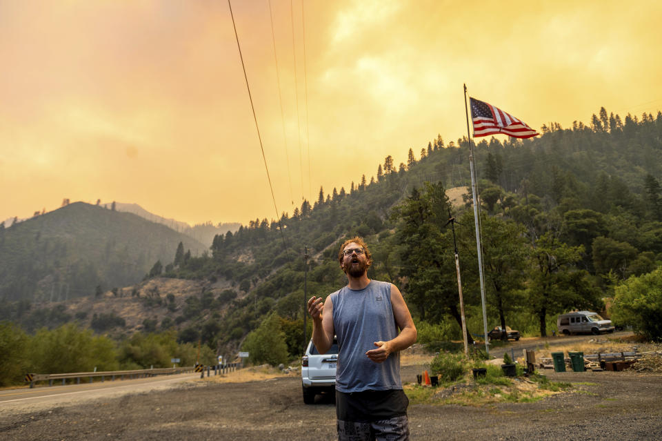 Benjamin Bell watches as the Dixie Fire burns along Highway 70 in Plumas National Forest, Calif., on Friday, July 16, 2021. (AP Photo/Noah Berger)