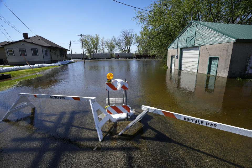 Barricades sit in floodwaters from the nearby Mississippi River, Monday, May 1, 2023, in Buffalo, Iowa. (AP Photo/Charlie Neibergall)