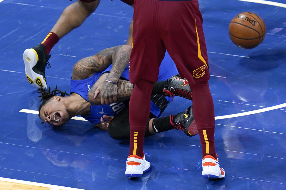 Orlando Magic guard Markelle Fultz screams and holds his knee after he was injured while going up for a shot against Cleveland Cavaliers defense during the first half of an NBA basketball game, Wednesday, Jan. 6, 2021, in Orlando, Fla. (AP Photo/John Raoux)