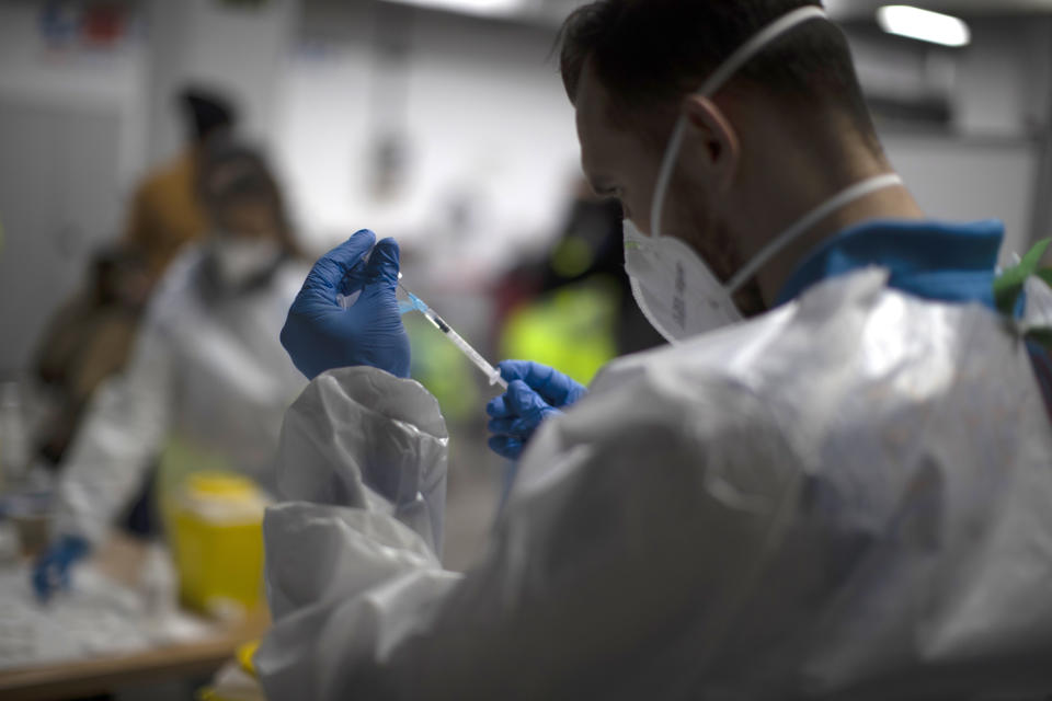 A health worker prepares the Pfizer-BioNTech COVID-19 vaccine for members of Madrid Emergency Service (SUMMA) in Madrid, Spain, Tuesday, Jan. 12, 2021. Spain's rate of infection has shot up to 435 cases per 100,000 residents in the past two weeks, prompting new restrictions as authorities try to bring vaccination up to speed. (AP Photo/Manu Fernandez)