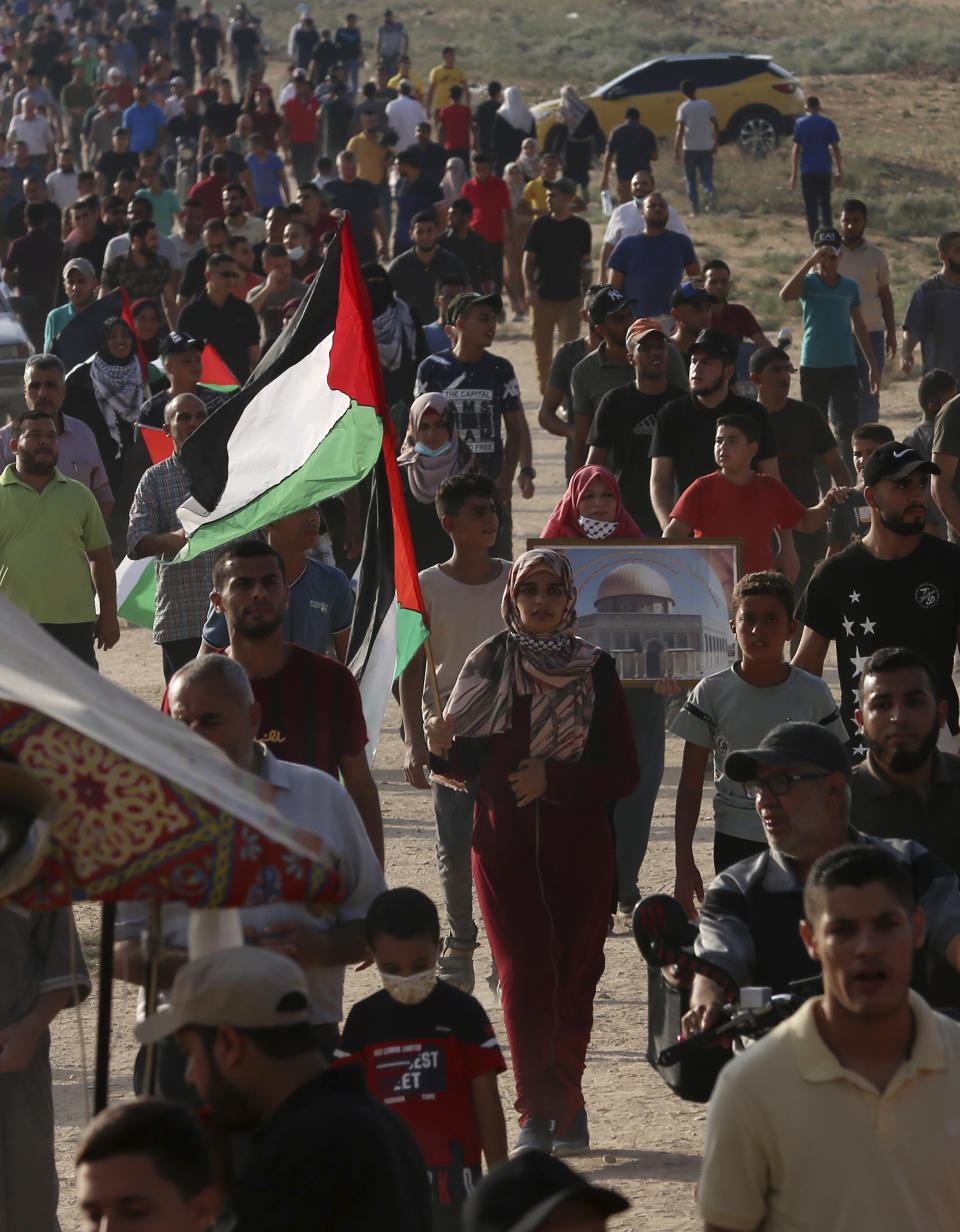 Protestors march toward the Gaza Strip's border with Israel, during a protest marking the anniversary of a 1969 arson attack at Jerusalem's Al-Aqsa mosque by an Australian tourist later found to be mentally ill, east of Gaza City, Saturday, Aug. 21, 2021. (AP Photo/Adel Hana)