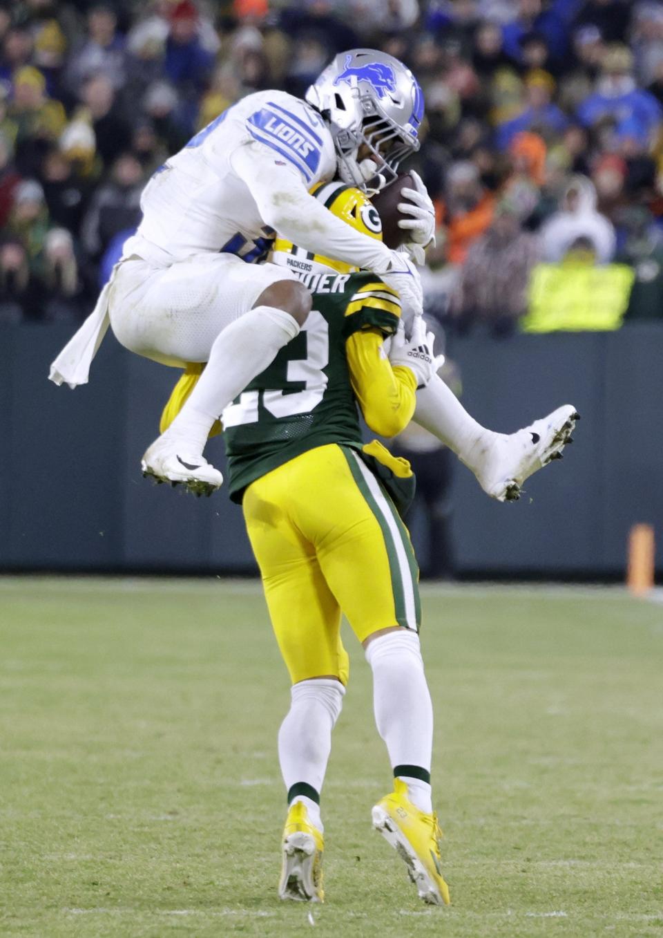 Lions running back D'Andre Swift attempts to hurdle Packers cornerback Jaire Alexander during the second half of the Lions' 20-16 win over the Packers on Sunday, Jan. 8, 2023, in Green Bay, Wisconsin.