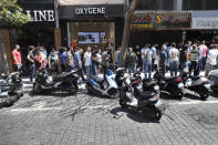 People line up outside an exchange shop to buy U.S. dollars, in Beirut, Lebanon, June 17, 2020. Lebanon's financial meltdown has thrown its people into a frantic search for dollars as the local currency's value evaporates. Long, raucous lines mass outside exchange bureaus to buy rationed dollars. Many try to rescue their dollars trapped in bank accounts frozen by the government. (AP Photo/Hussein Malla)