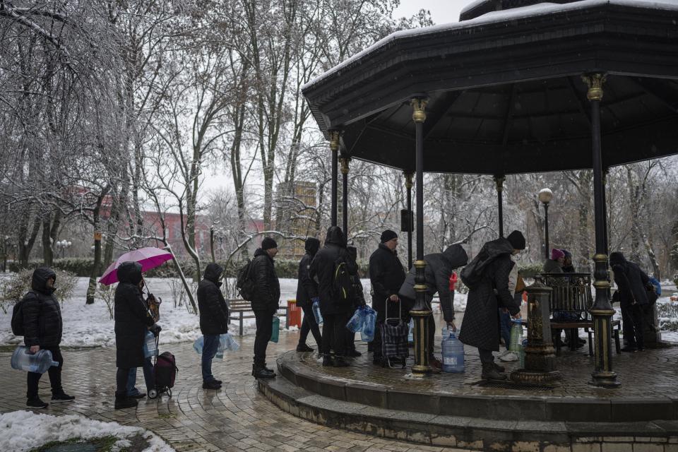 FILE - People wait in line to collect water, in Kyiv, Ukraine, Nov. 24, 2022. The hard realities of Ukraine’s capital are that a once comfortably livable city of 3 million people is now becoming a tough place to live. But Kyiv has hope, resilience and defiance in abundance. And perhaps more so now than at any time since Russia invaded Ukraine nine months ago. (AP Photo/Evgeniy Maloletka, File)