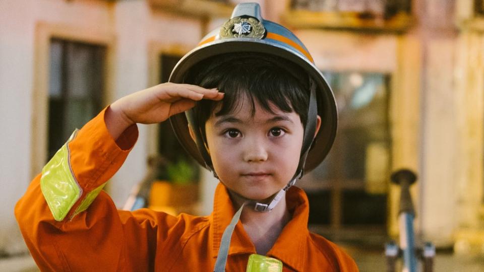 Niño con un traje de bombero.