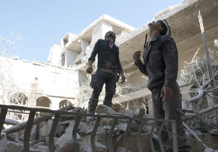 Syrian rescue workers in the Jallum neighbourhood of Aleppo on June 14, 2015 following a reported barrel bomb attack by Syrian government forces