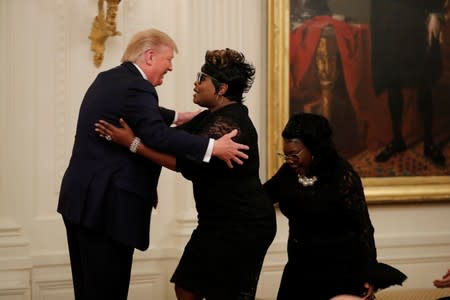 Diamond and Silk join U.S. President Trump onstage at his social media forum at the White House in Washington