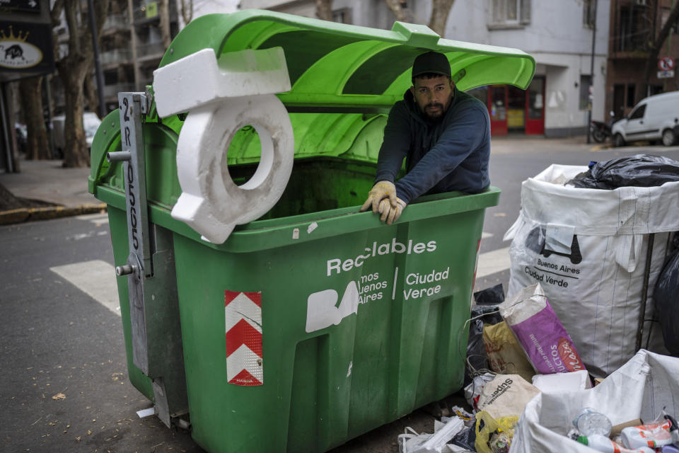 Francisco Leiva, 28, poses for a photo from inside a garbage container while recycling cardboard, plastics and metal to sell in Buenos Aires, Argentina, Monday, July 4, 2022. About four of every 10 Argentines are poor. (AP Photo/Rodrigo Abd)