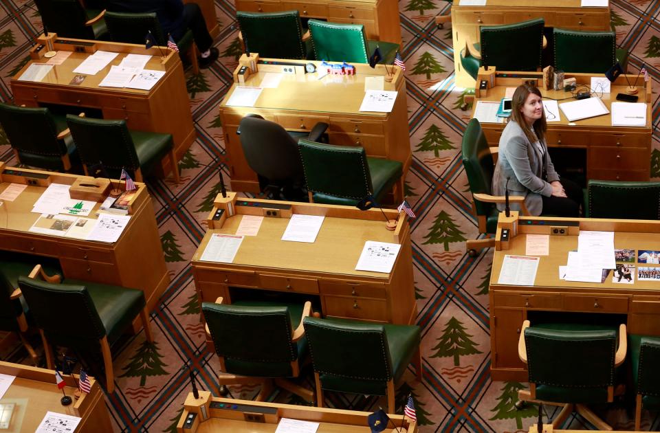 Rep. Cheri Helt, R-Bend, sits among the empty desks of her Republican colleagues in the Oregon State Capitol in Salem on Tuesday.