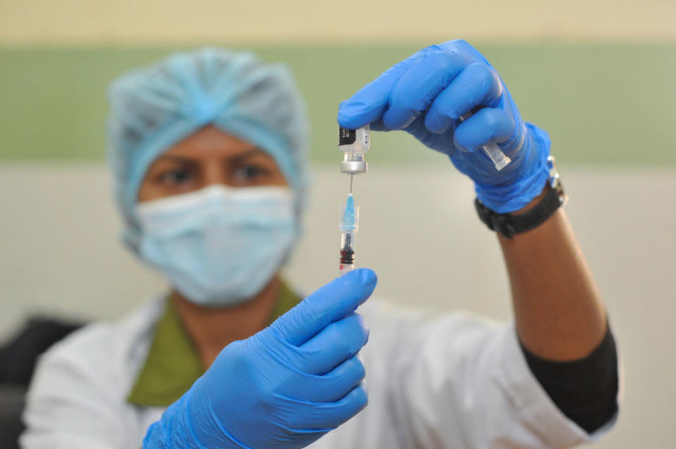 A health worker prepares the Pfizer booster dose during a mass vaccination campaign at the M A G Osmani medical college & hospital vaccination centre. 